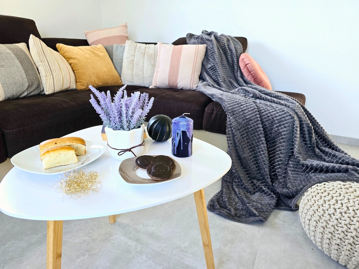 Gem&uuml;tliche Sofaecke mit Kuchen und Lavendel-Dekoration