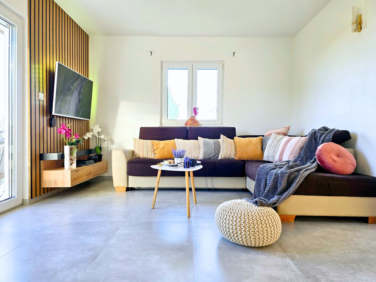 Wohnzimmer mit Schlafsofa, Smart TV und Balkon