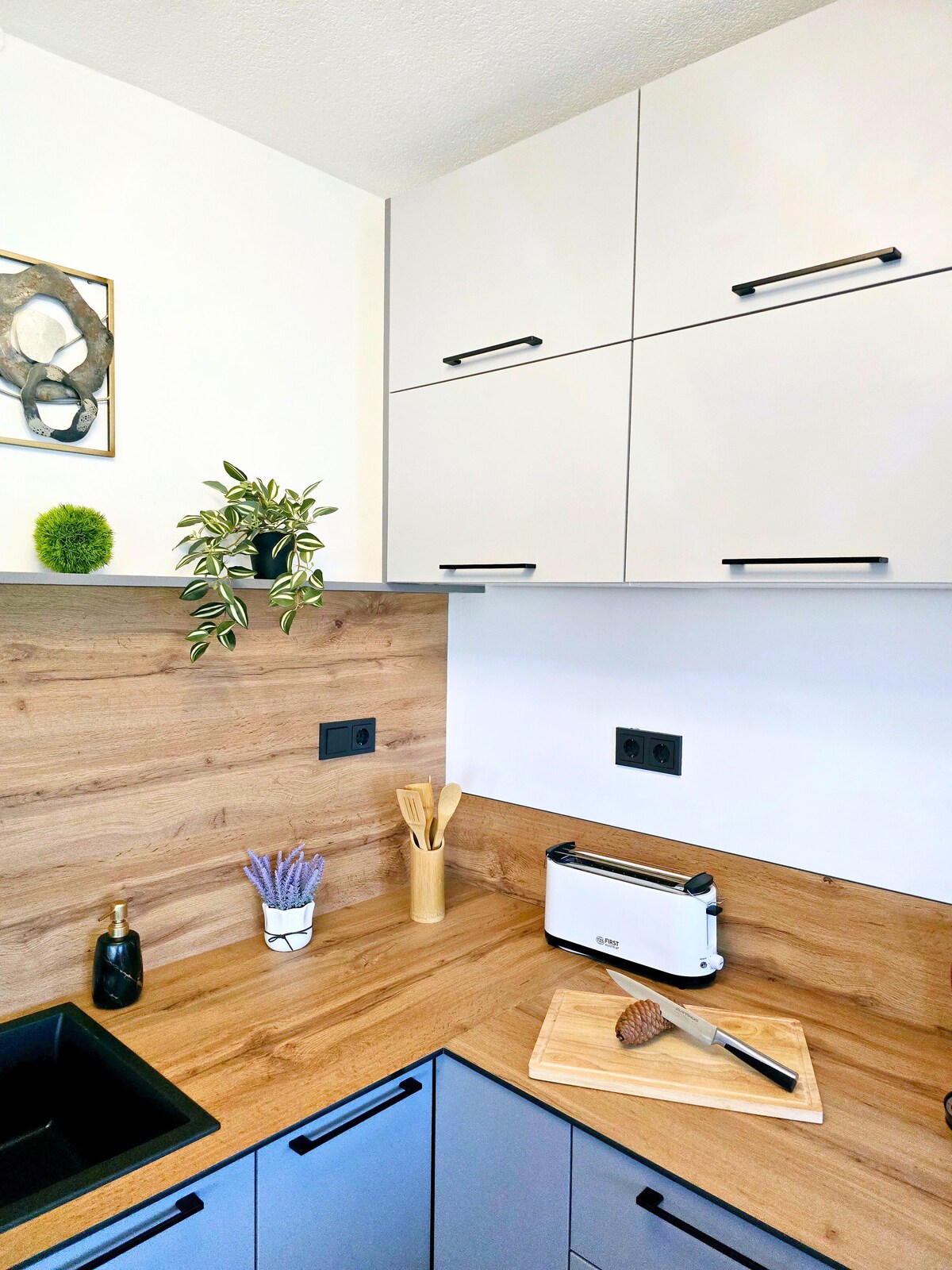 K&uuml;chenecke mit Schneidebrett, Toaster und Holzr&uuml;ckwand