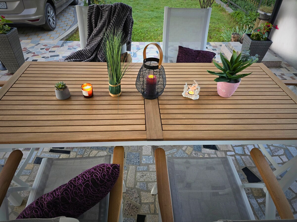 Terrassen-Esstisch mit Kerzen und Pflanzen f&uuml;r Abendessen im Freien