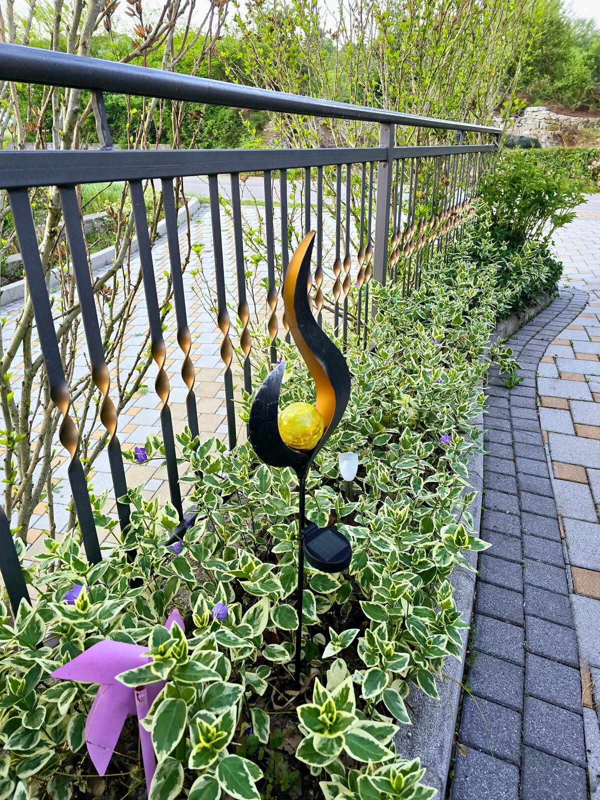 Gartenweg mit Solarlampe und gr&uuml;ner Bepflanzung