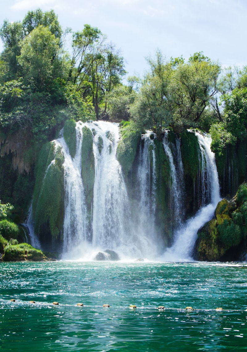 Close-up of Kravica waterfall cascading over moss-covered rocks